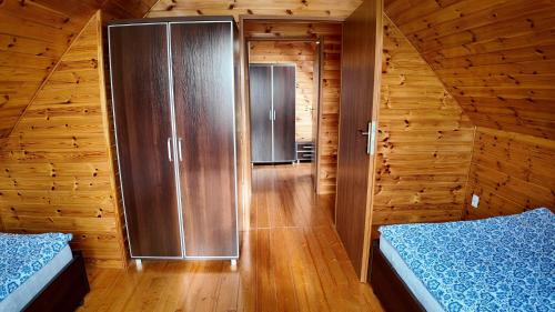 a room with two beds in a wooden cabin at Sosnowe Domki in Sarbinowo