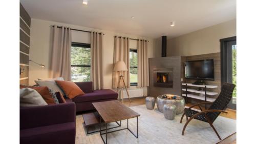 a living room with a purple couch and a tv at Bavarian Chalet 1 in Taos Ski Valley