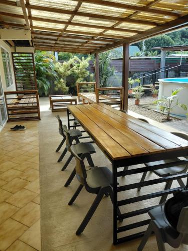 a wooden table and chairs on a patio at Spacious Family House with Pool in Afareaitu