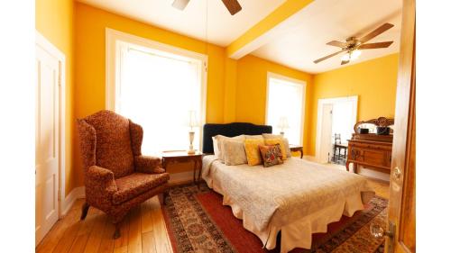 a bedroom with yellow walls and a bed and a chair at William F. Cody in Cimarron