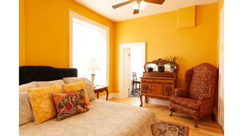 a bedroom with yellow walls and a bed and a chair at William F. Cody in Cimarron