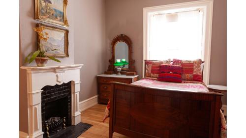 a bedroom with a fireplace and a mirror at Bat Masterson in Cimarron