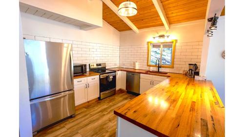 a kitchen with a stainless steel refrigerator and a wooden floor at Aspen Hideaway in Red River