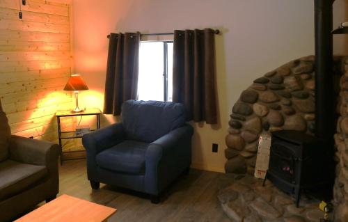 a living room with a blue chair and a fireplace at Arrowhead 01 Townhouse in Red River