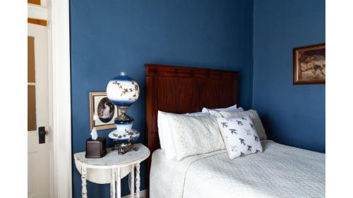a blue bedroom with a bed and a side table at Annie Oakley in Cimarron