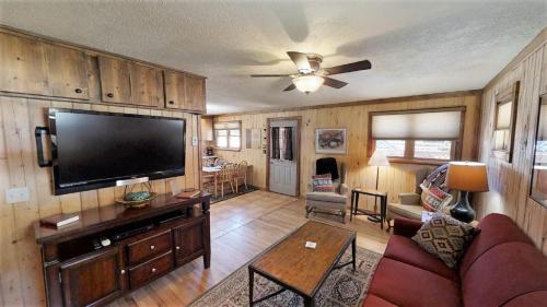 a living room with a large flat screen tv at Knotty & Nice in Red River