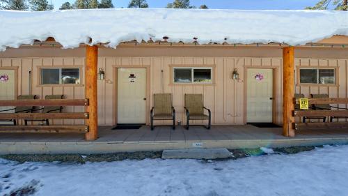 a covered porch of a cabin with snow on the roof at Arrowhead 09 in Red River