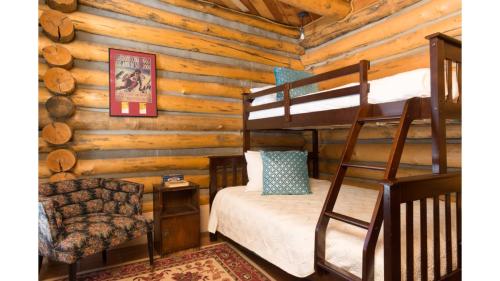 a bedroom with a bunk bed in a log cabin at Denton Cabin in Taos Ski Valley