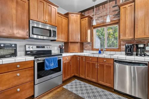 a kitchen with wooden cabinets and stainless steel appliances at Beaver Lake Hideaway in Lowell