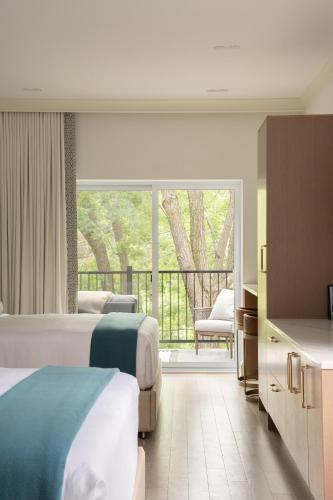 a hotel room with two beds and a balcony at Manoir Émery in Montreal