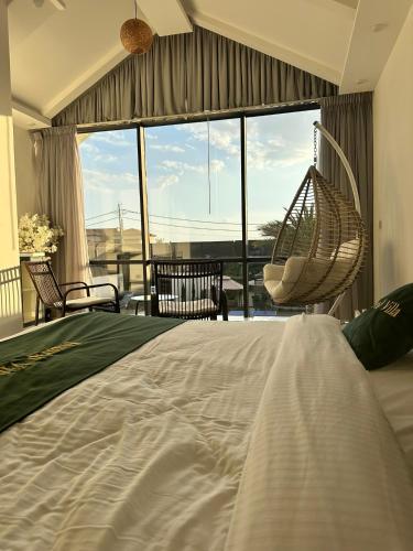 a bedroom with a swinging bed and a large window at Madrid Luxury Villa in Al Rama