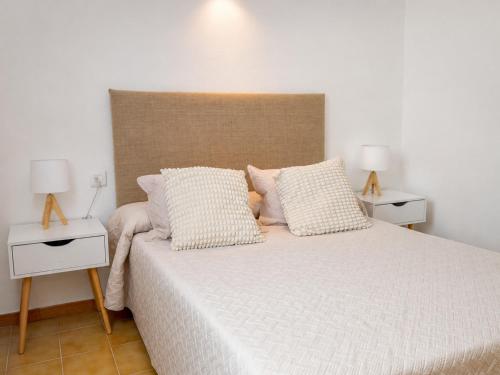 a bedroom with a large bed with two night stands at Formenterasuite 16 in Es Pujols