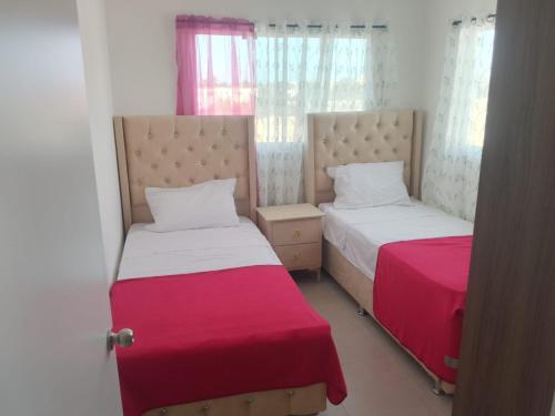 two beds sitting next to each other in a room at Rinconcito Caribeno Apartment in San Pedro de Macorís