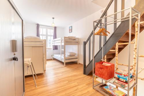 a room with a staircase and bunk beds at Gîte la Maison Rouge Béthune in Béthune