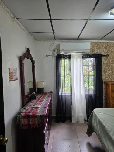 a bedroom with a mirror and a dresser and a window at La casa de Juana in Las Tablas