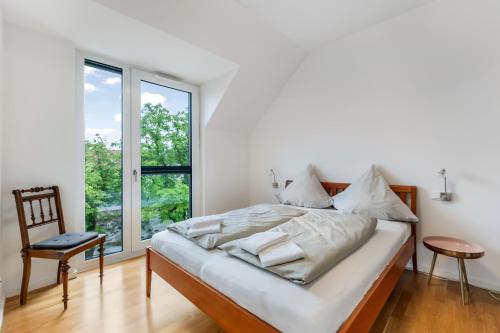 a bedroom with a bed and a chair and a window at Ferienwohnung Urlaubsglück- lichtdurchflutete Wohnung mit Balkon und Seesicht in Lindau
