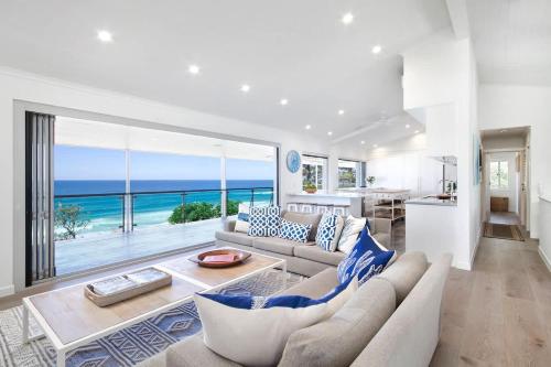a living room with a couch and a view of the ocean at Ocean Panorama With Private Pool! in Noosa Heads
