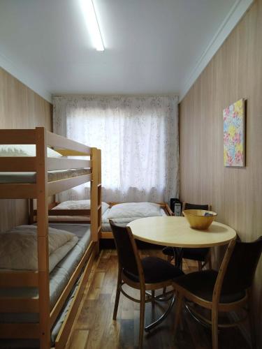 a room with a bunk bed and a table and chairs at Chalmová CHATA 27 in Bystričany