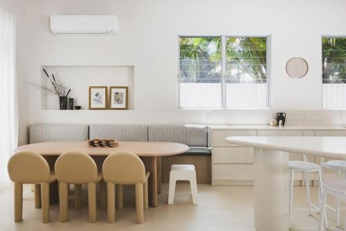a white kitchen with a table and chairs at Coastal Haven on Witta in Noosa Heads