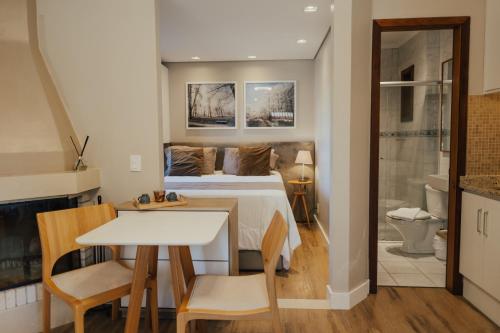 a bedroom with a bed and a table and chairs at Cabanas Belo Destino in Gramado