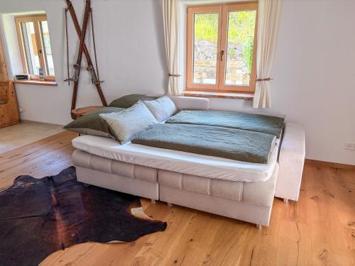 a couch sitting in a room with a window at Alpenchalet Wasserfallblick in Ramsau