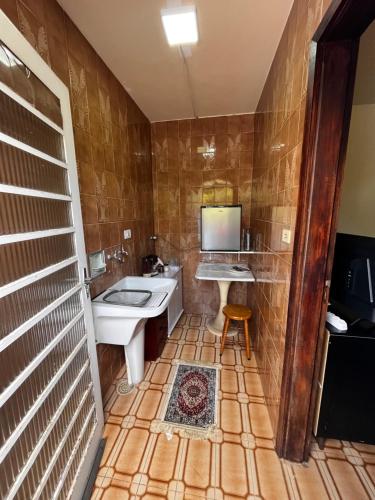 a bathroom with a sink and a tub and a toilet at Quarto triplo - Casa Azul - Águas de São Pedro in Águas de São Pedro