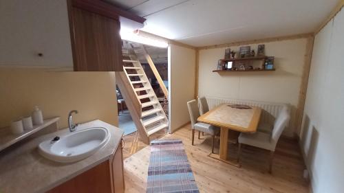 a bathroom with a sink and a table in a room at Chata Milka in Medzilaborce