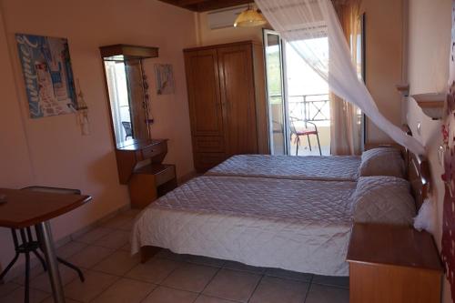 a bedroom with a bed and a table and a window at Kapitan in Arillas