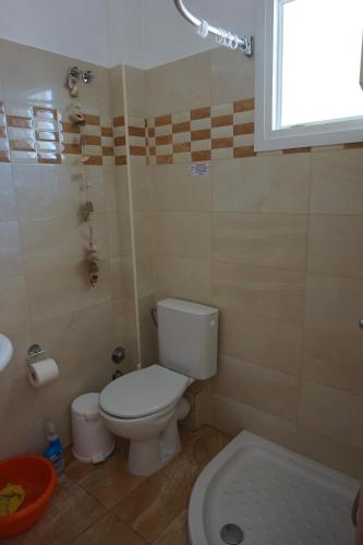 a bathroom with a white toilet and a sink at Kapitan in Arillas