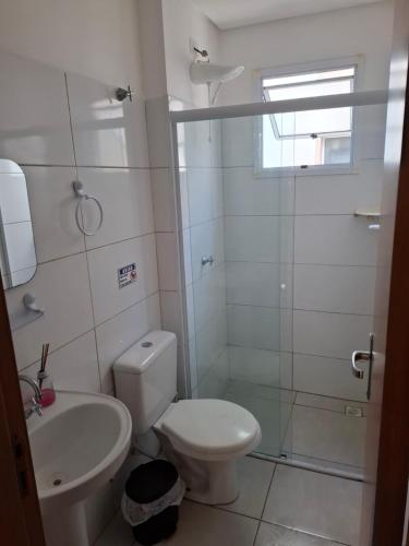 a bathroom with a toilet and a sink and a shower at Apartamentos Gratitude in Ubatuba