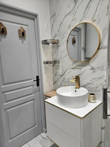 a white bathroom with a sink and a mirror at Le coeur de Mers in Mers-les-Bains