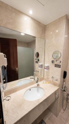 a bathroom with a sink and a mirror at فندق الأرضُ المتميزه - Land Prime -1 in Mecca
