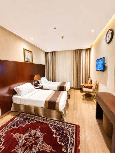 a hotel room with two beds and a television at فندق الأرضُ المتميزه - Land Prime -1 in Mecca