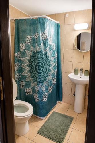 a bathroom with a shower curtain with a toilet and a sink at Traditional House in Laerma in Láerma