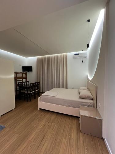 a bedroom with a bed and a dining room at Hotel Otrant in Velipojë