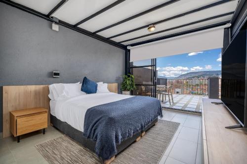 a bedroom with a bed and a balcony with a view at Park 38 in Envigado