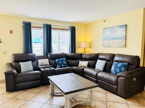 a living room with a leather couch and a table at Put-in-Bay Poolview Condo #4 in Put-in-Bay