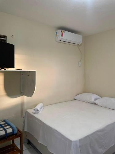 a bedroom with a white bed with a fan at Pousada BR 423 in Garanhuns