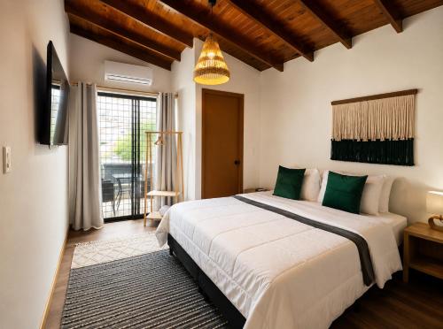 a bedroom with a large bed and a large window at Luum Guest House Manila in Medellín