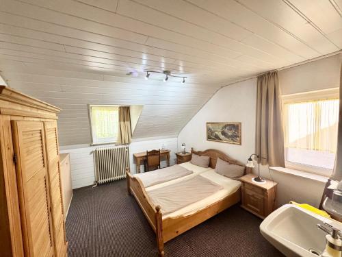 a bedroom with a bed and a sink in it at Hotel Bauernstube in Oberhausen