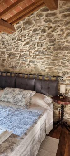 a bedroom with a stone wall with a bed at Tuscany House Retreat in Casentino in Subbiano