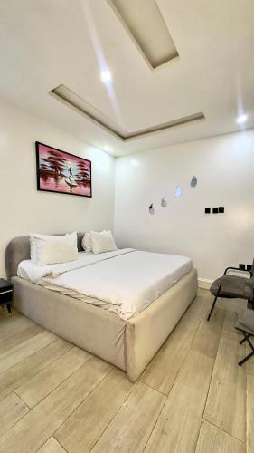 a white bedroom with a large bed in a room at Leria Living luxury 2 bedroom wuye, Abuja in Ankuru