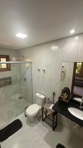 a bathroom with a toilet and a shower and a sink at A Casa da lua in Lagoa Santa