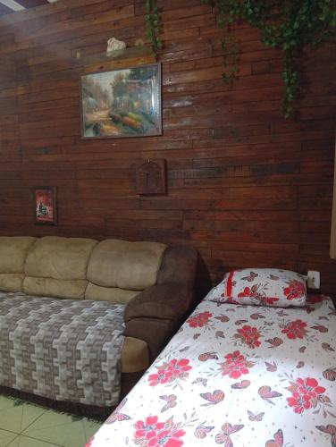 a living room with a couch and a bed at Casacapuba Jacaraipe Es in Serra
