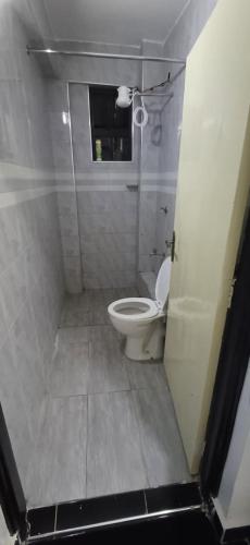 a small bathroom with a toilet and a window at Chateau Haven in Kakamega