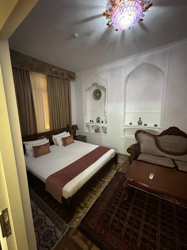 a bedroom with a large bed and a chandelier at Orom Hotel & Terrace in Bukhara