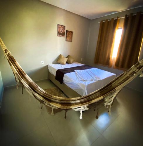 a bedroom with a bed in a hanging bed frame at Espaço Sonhos da Serra in Bananeiras