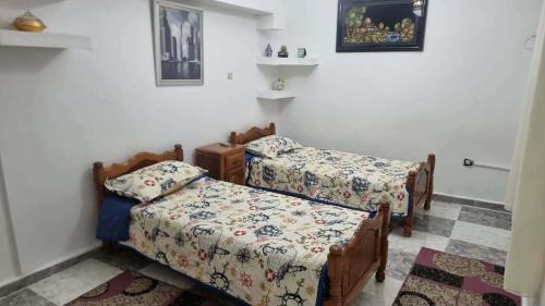 two beds in a small room with white walls at Location salamandre in Mostaganem
