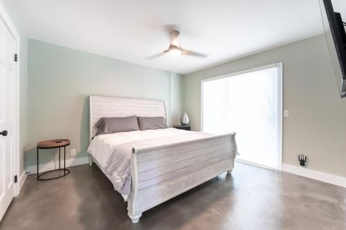 a bedroom with a white bed and a large window at Coastal Escape for 2 - Pool, Fire Pit & Beach Access in Saint Simons Island