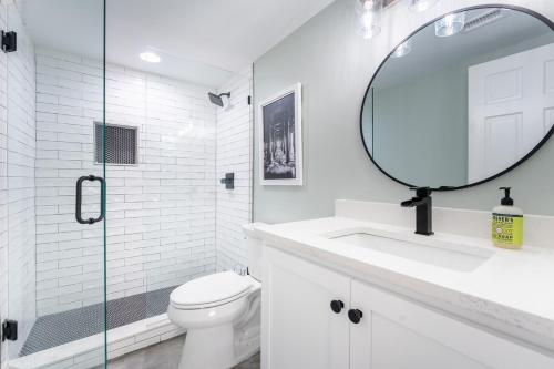 a white bathroom with a sink and a mirror at Coastal Escape for 2 - Pool, Fire Pit & Beach Access in Saint Simons Island